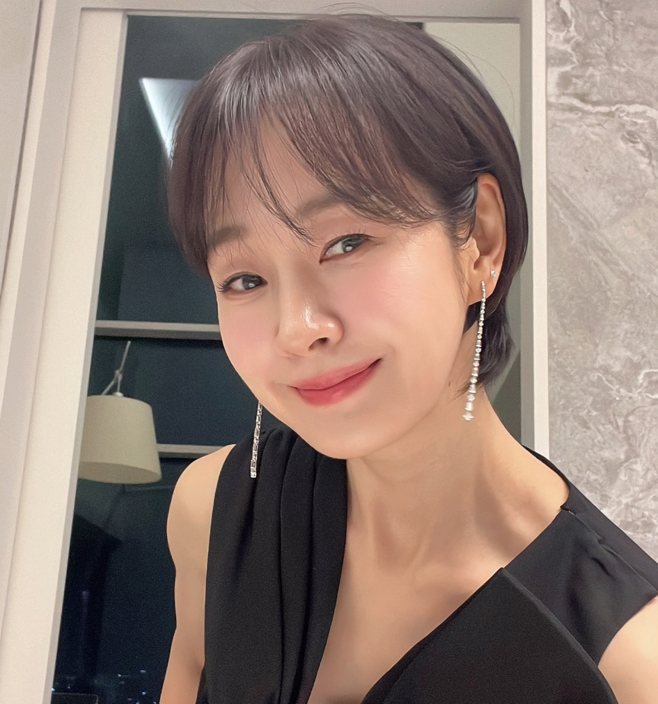 명세빈이 짧은 머리로 변신한 뒤 거울 앞에서 미소 짓고 있다
