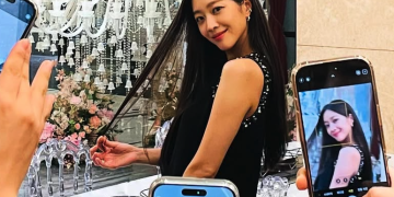 화려한 샹들리에 앞에서 머리를 쓸어 넘기며 미소 짓는 조보아를 여러 대의 휴대폰 카메라가 촬영하는 장면
