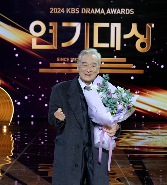 KBS 연기대상 무대에서 꽃다발을 들고 미소 짓는 배우 이순재