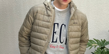 회색 맨투맨 티셔츠 위에 베이지색 AECA 패딩 점퍼를 입고 주머니에 손을 넣은 채 카메라를 정면으로 응시하고 있는 배우 안재현의 모습