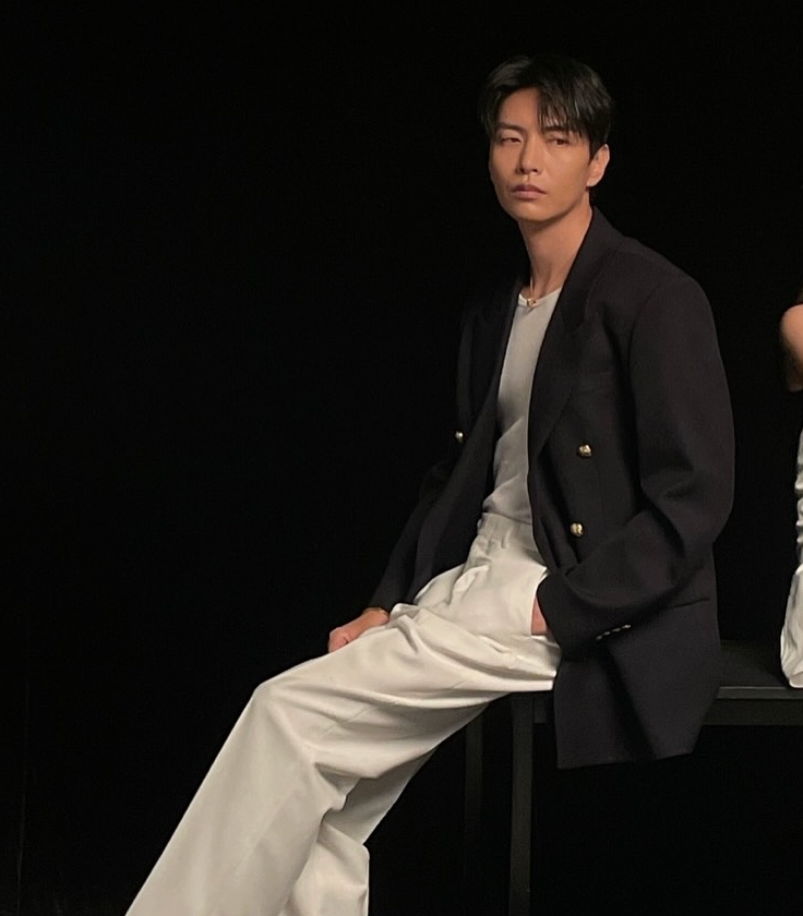 이민기가 CINE21 화보 촬영 중 블랙 재킷과 화이트 팬츠를 입고 포즈를 취하고 있는 모습