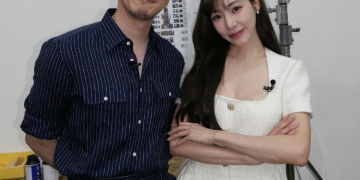 티파니 영과 변요한이 팔짱을 끼고 나란히 서서 카메라를 응시하는 모습. 변요한은 안경과 줄무늬 셔츠를, 티파니는 흰색 반팔 원피스를 착용하고 있다.