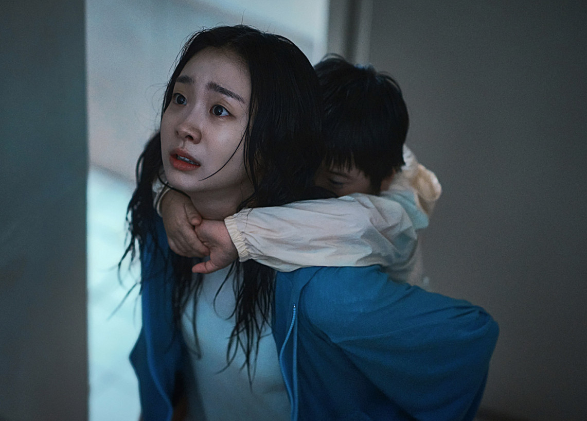 영화 대홍수에서 아역배우를 업고 달리는 김다미의 모습