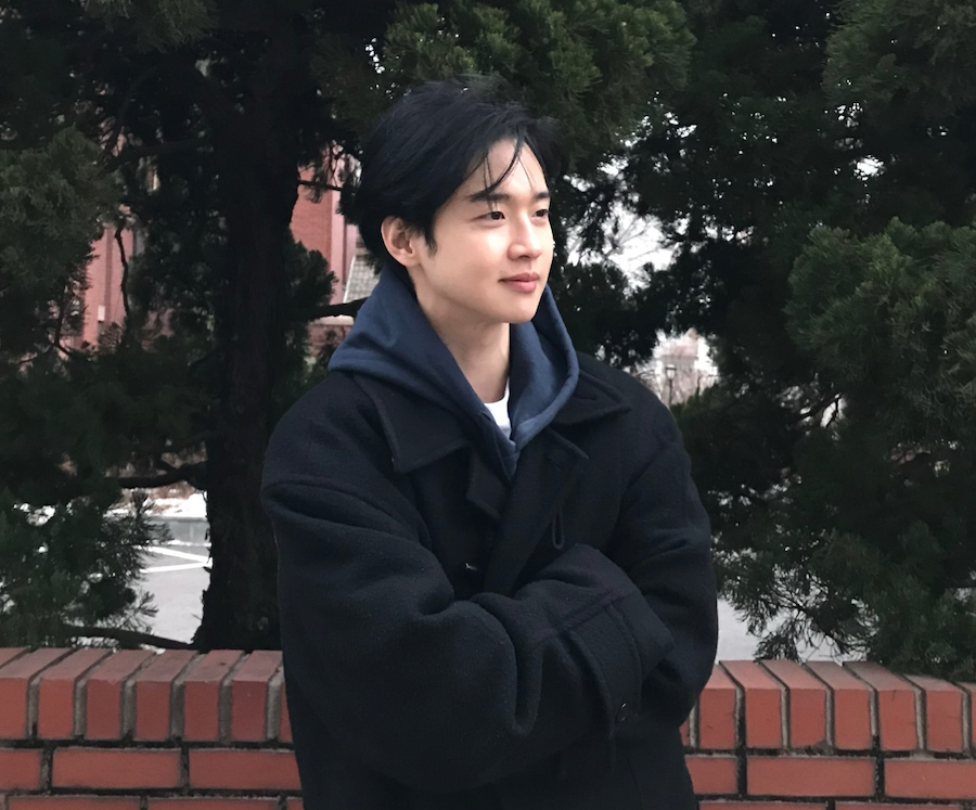 벽돌 담장 앞에서 캐주얼 차림으로 서 있는 장동윤의 SNS 일상 사진