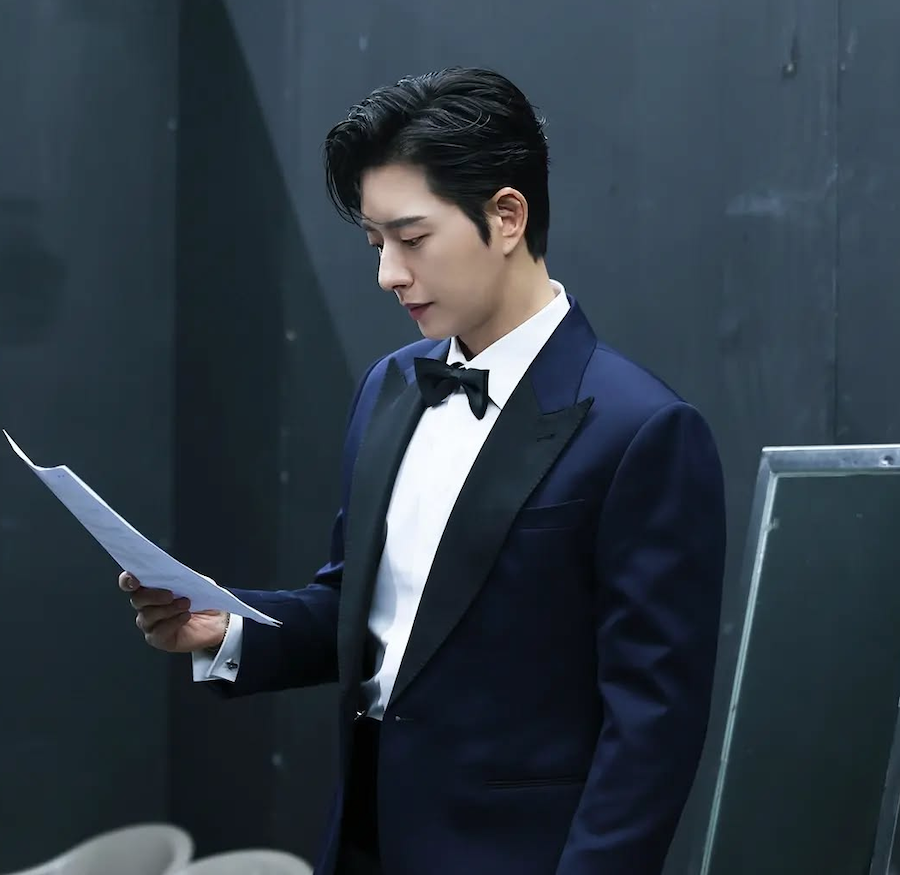 시상식 무대 뒤에서 턱시도를 입고 대본을 확인하는 배우 박해진의 모습